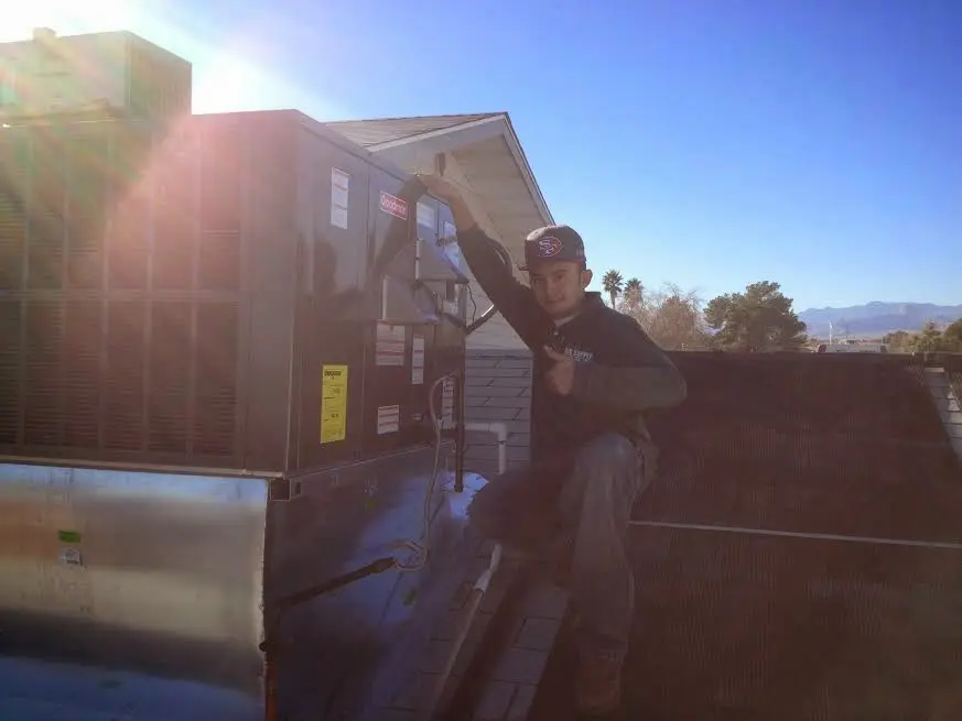 HVAC technician performing Air Duct Cleaning on a rooftop unit in Lewistown